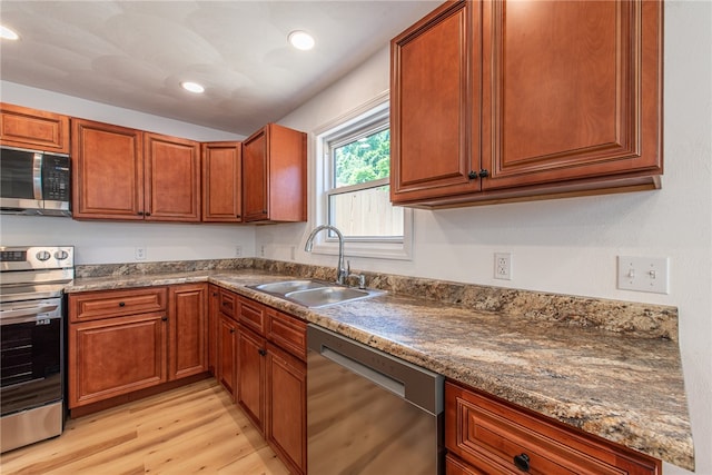 kitchen featuring stainless steel appliances, sink, and light wood-type flooring