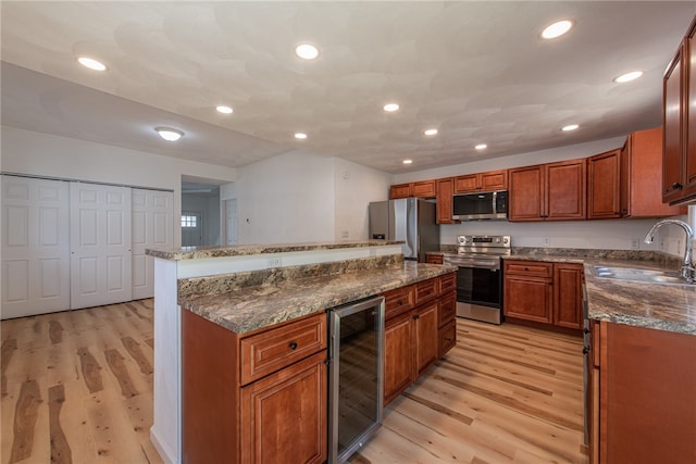 kitchen with a kitchen island, wine cooler, light hardwood / wood-style flooring, stainless steel appliances, and sink