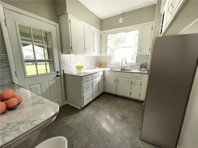 kitchen featuring plenty of natural light, sink, white cabinetry, and fridge