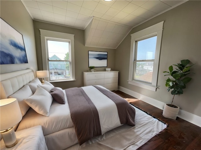 bedroom featuring wood-type flooring, multiple windows, and vaulted ceiling