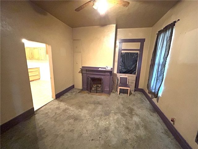 unfurnished living room featuring ceiling fan and a fireplace