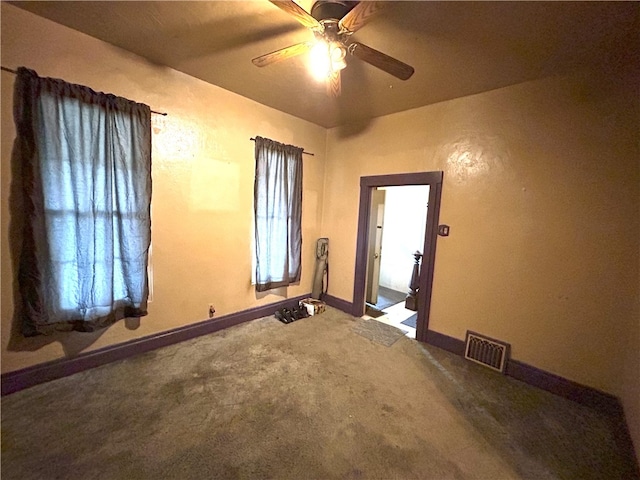 carpeted spare room featuring a healthy amount of sunlight and ceiling fan