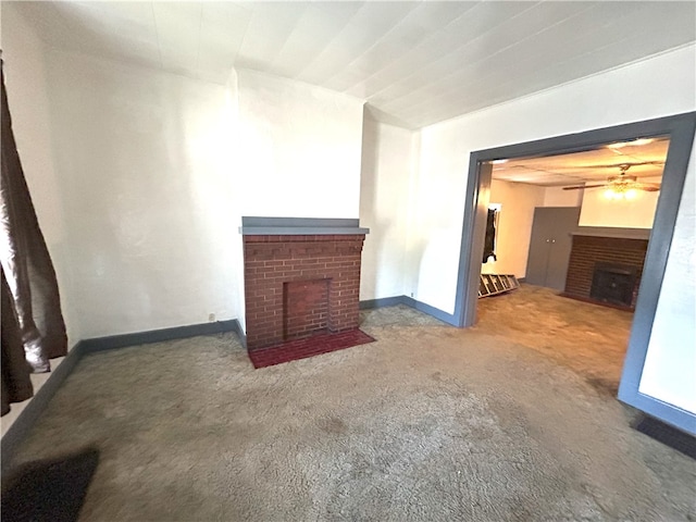 unfurnished living room with carpet, a brick fireplace, and ceiling fan