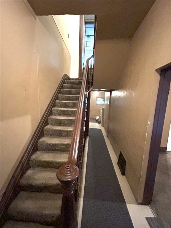 staircase featuring a towering ceiling