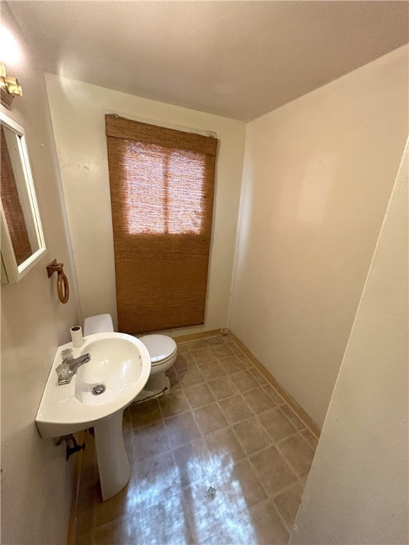 bathroom with sink, tile flooring, and toilet