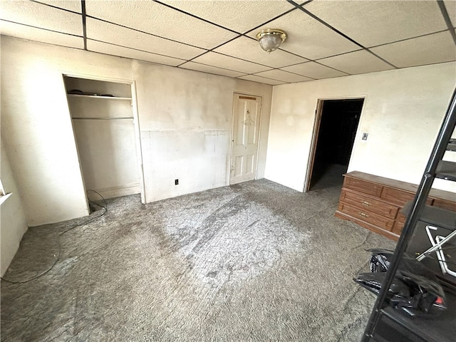 unfurnished bedroom with a closet and a paneled ceiling