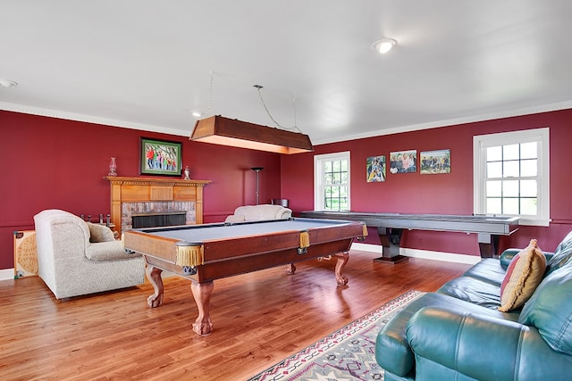 rec room with ornamental molding, hardwood / wood-style floors, pool table, and a brick fireplace