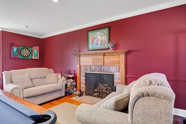 living room with hardwood / wood-style floors, crown molding, and a fireplace