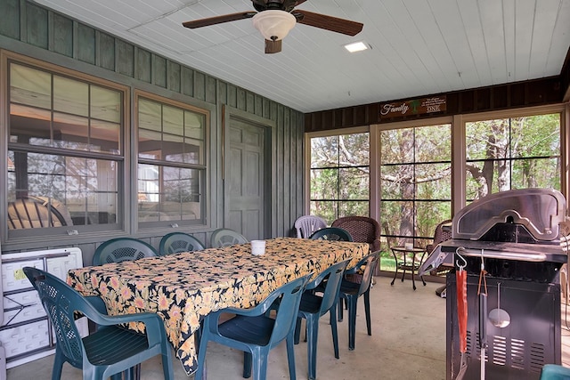 dining area featuring wooden walls and ceiling fan