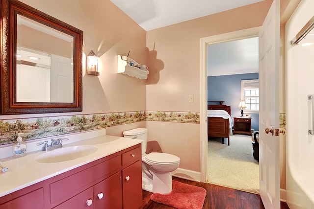 bathroom with vanity, toilet, and hardwood / wood-style floors