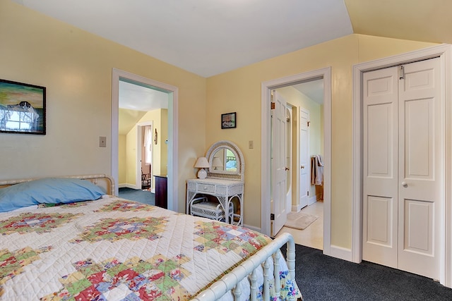 carpeted bedroom with a closet and vaulted ceiling