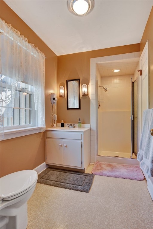 bathroom with vanity, toilet, and tiled shower