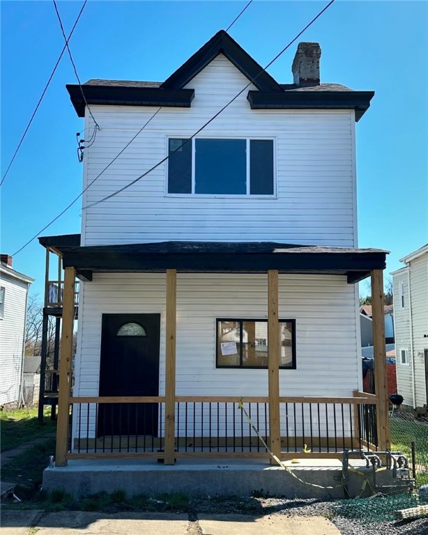 view of front of home featuring a porch and a chimney