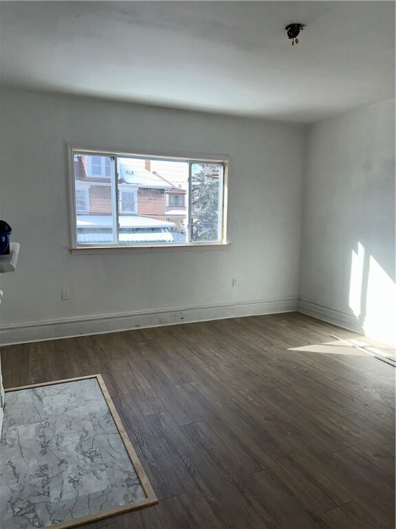 unfurnished room featuring baseboards and wood finished floors