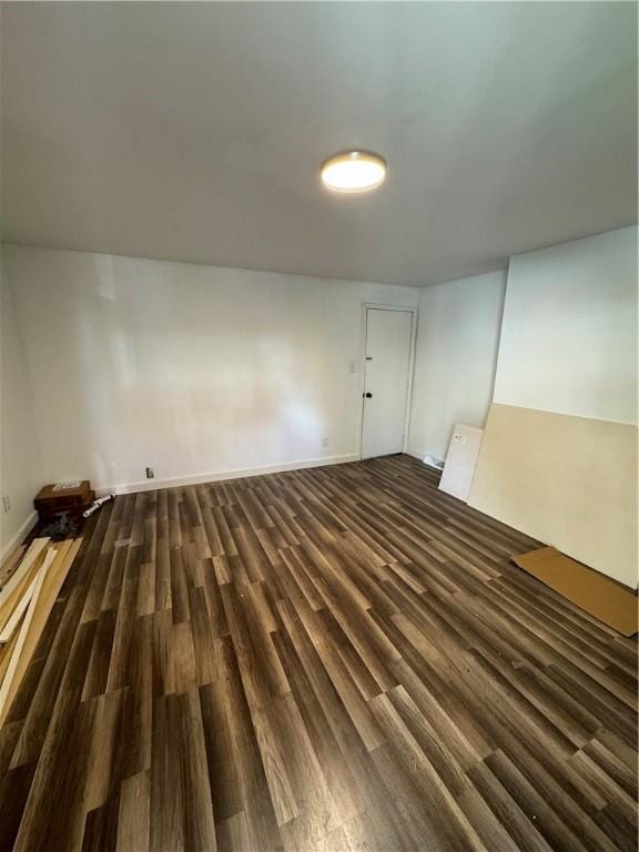 unfurnished room featuring dark wood-style flooring and baseboards