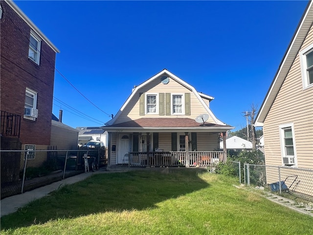 view of front of property featuring cooling unit, covered porch, and a front yard