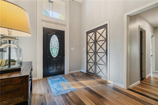 foyer featuring a towering ceiling and hardwood / wood-style flooring