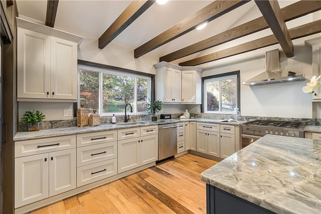 kitchen with wall chimney range hood, light hardwood / wood-style flooring, light stone countertops, beam ceiling, and appliances with stainless steel finishes