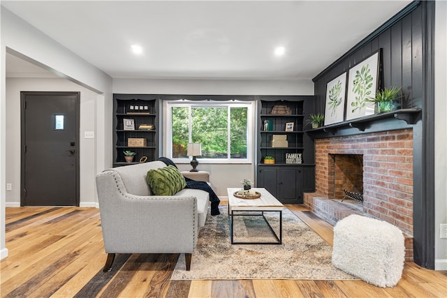 living room featuring a brick fireplace and hardwood / wood-style floors