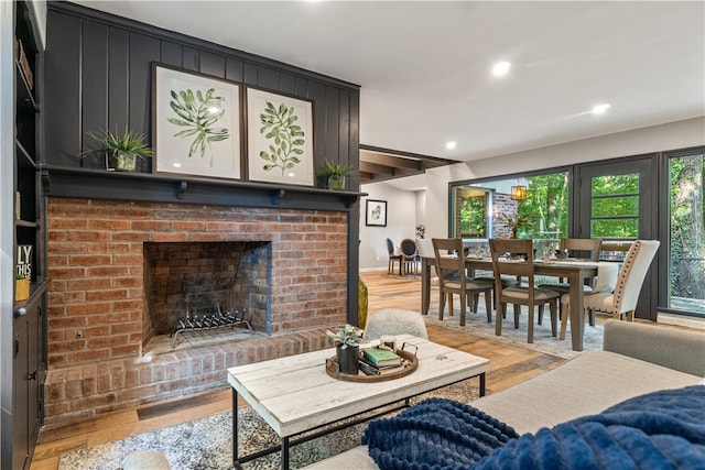 living room with hardwood / wood-style floors and a brick fireplace