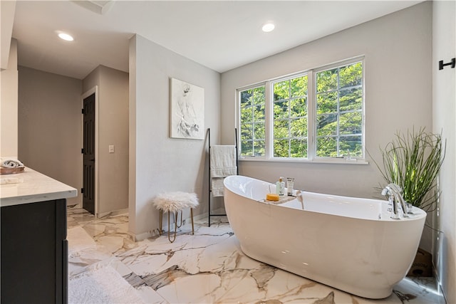 bathroom featuring tile floors, a bathing tub, and vanity