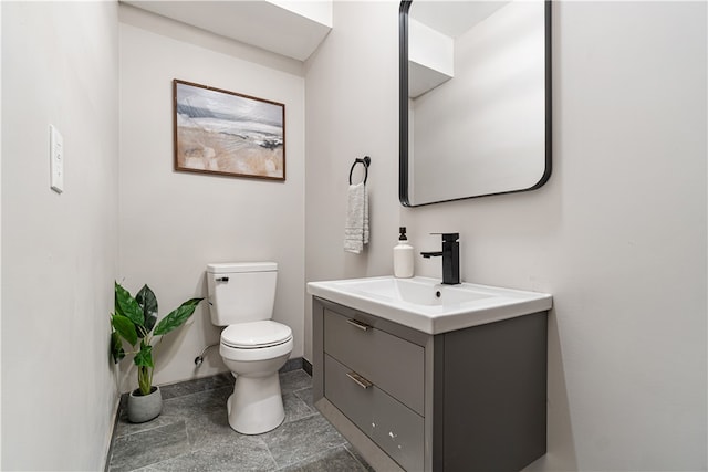 bathroom featuring tile flooring, vanity, and toilet