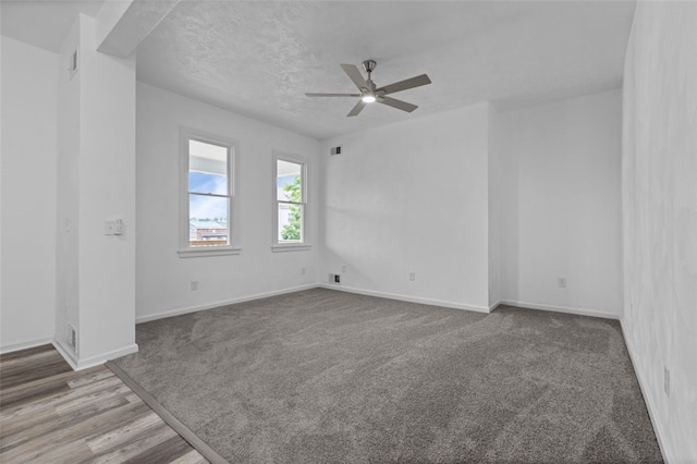 empty room with ceiling fan, a textured ceiling, and hardwood / wood-style flooring