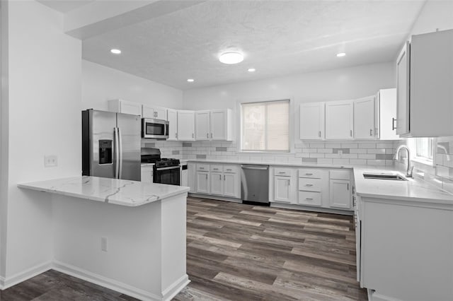 kitchen with white cabinets, appliances with stainless steel finishes, sink, and dark hardwood / wood-style floors