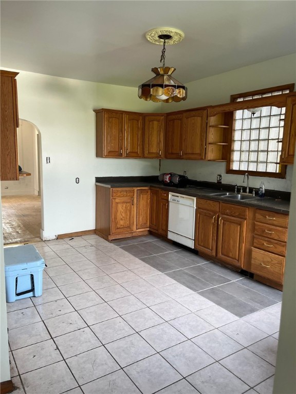 kitchen with sink, dishwasher, and light tile floors