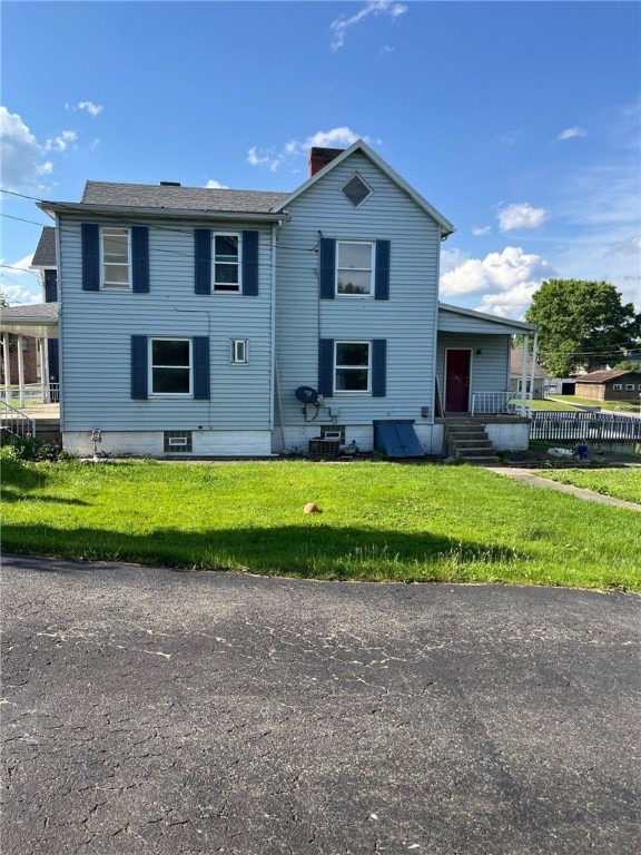 view of front of house with a front yard and central AC unit