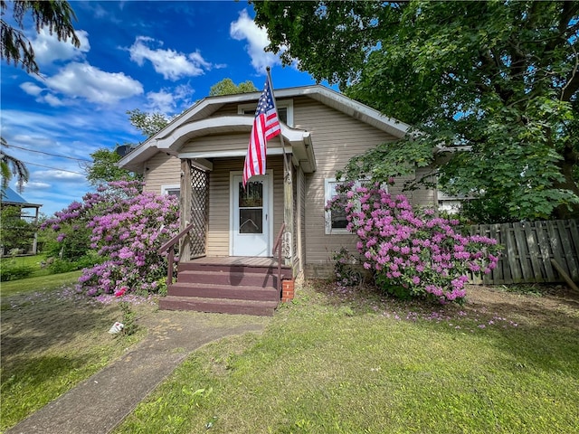 bungalow-style home featuring a front lawn