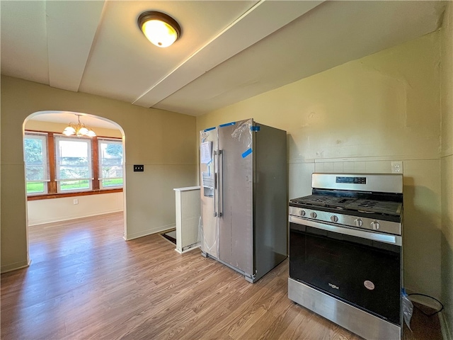 kitchen featuring light hardwood / wood-style floors, an inviting chandelier, and stainless steel appliances