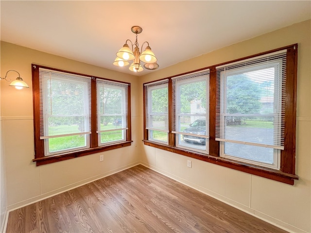 spare room featuring a chandelier and hardwood / wood-style flooring