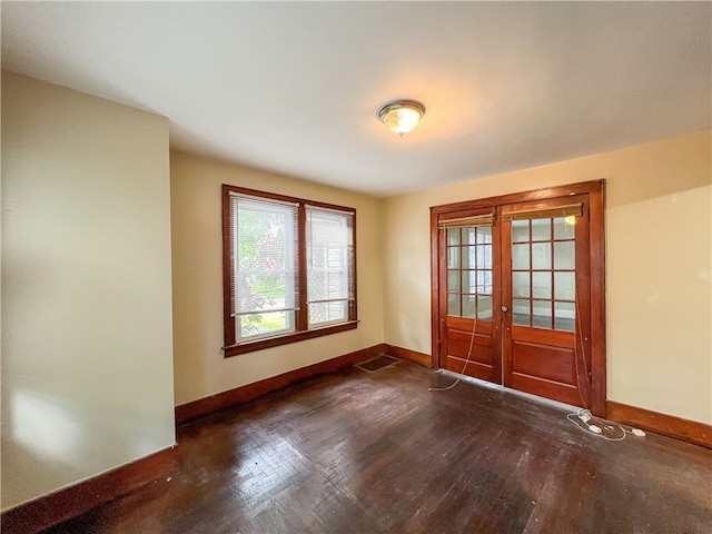 empty room with french doors and dark wood-type flooring