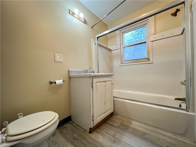 full bathroom with wood-type flooring, combined bath / shower with glass door, vanity, and toilet