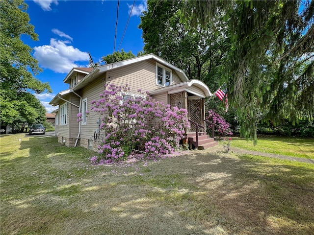 view of side of home with a lawn