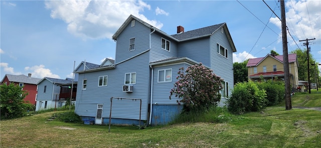 rear view of house featuring a lawn