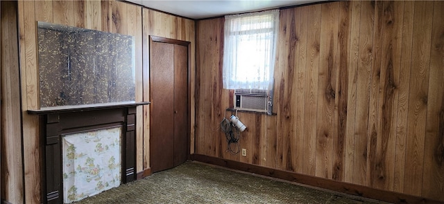 empty room with wooden walls and dark colored carpet