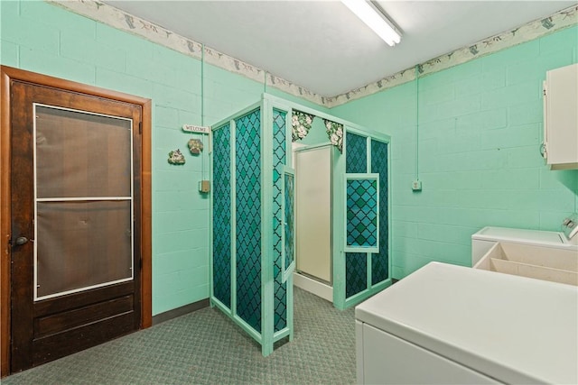 bathroom with a shower with door and washer and clothes dryer