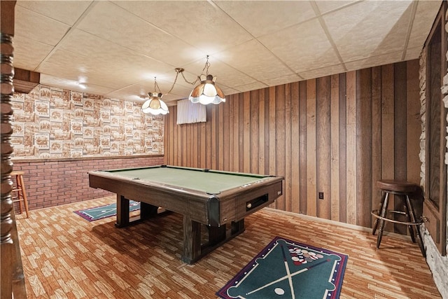 game room with a paneled ceiling, wood walls, and pool table