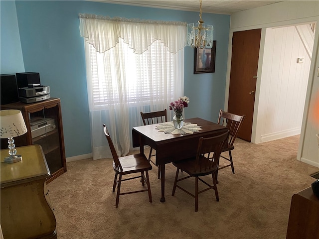 dining space featuring an inviting chandelier and carpet floors