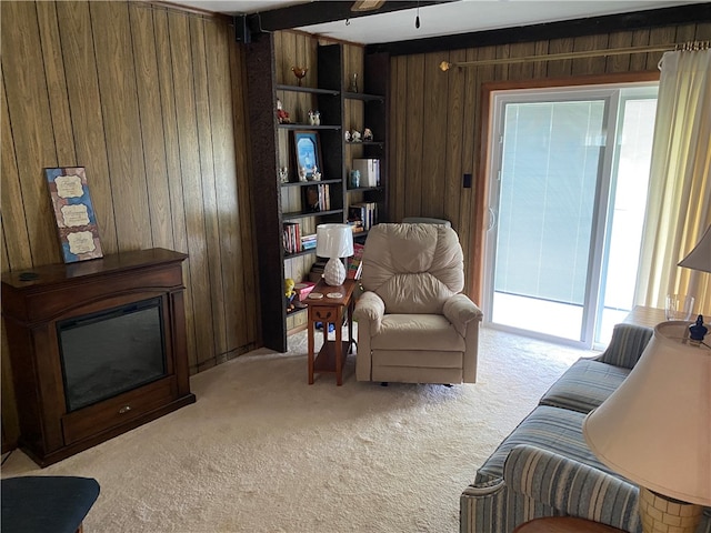 carpeted living room with wood walls