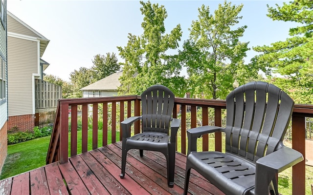 wooden deck featuring a lawn