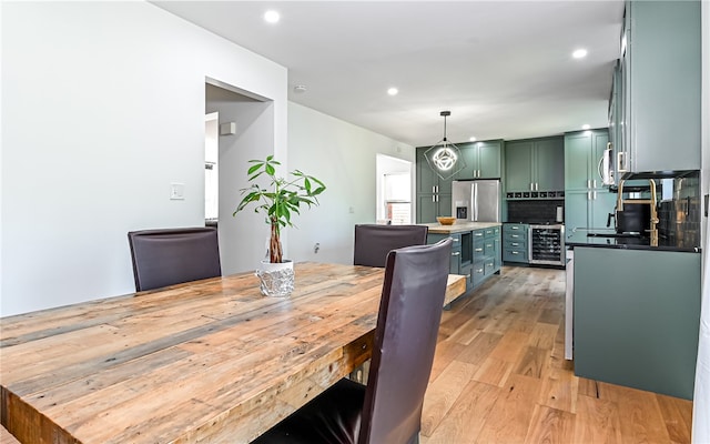 dining room with light hardwood / wood-style floors and beverage cooler