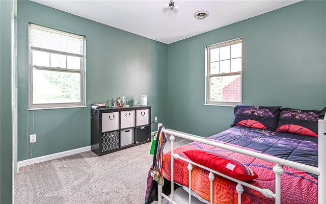 carpeted bedroom featuring multiple windows