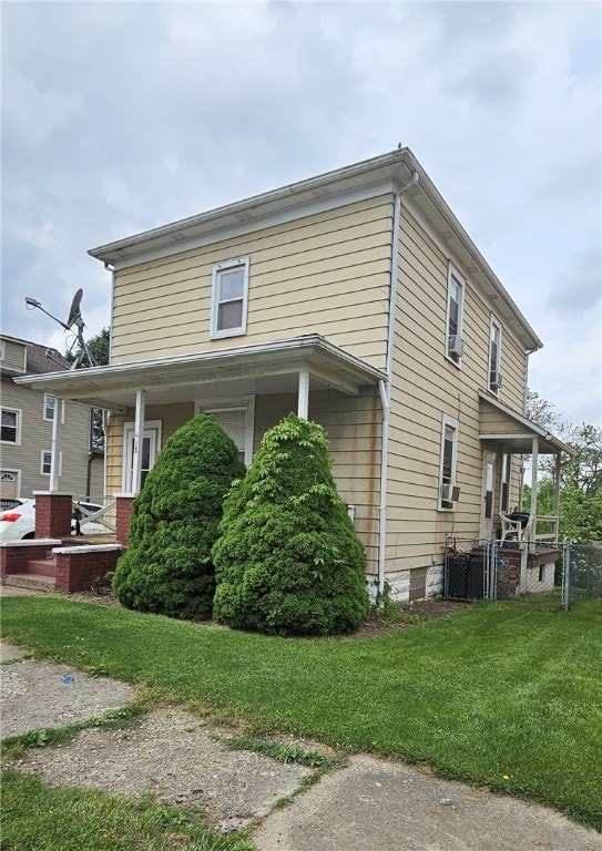 view of home's exterior featuring a porch and a yard