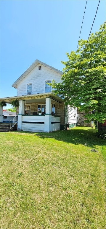 rear view of property with a yard