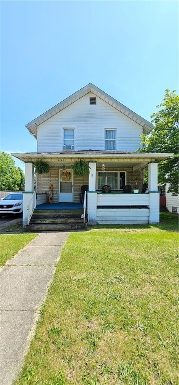 view of front facade featuring a front yard and covered porch