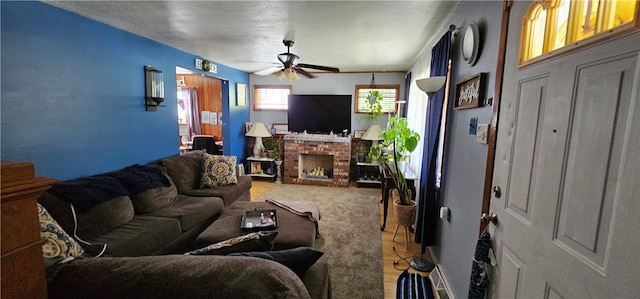 living room with ceiling fan and a fireplace