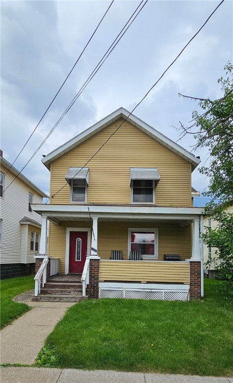 view of front facade featuring covered porch and a front lawn